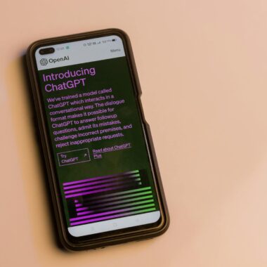 Webpage of ChatGPT, a prototype AI chatbot, is seen on the website of OpenAI, on a smartphone. Examples, capabilities, and limitations are shown.